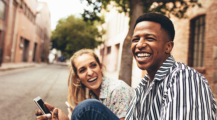 Couple sitting with each other holding phone