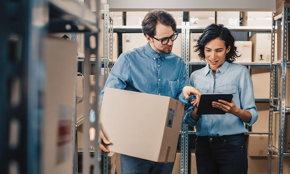 Workers looking at tablet in warehouse